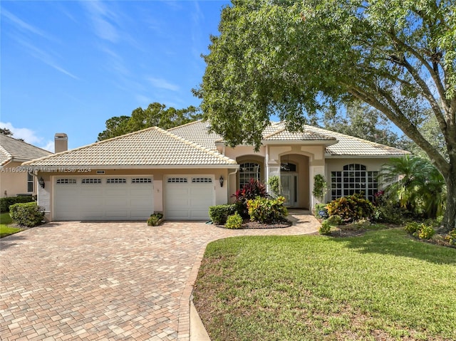 mediterranean / spanish-style house with a front yard and a garage