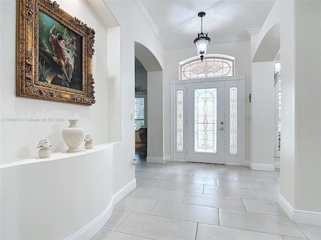 tiled foyer entrance with crown molding and a textured ceiling