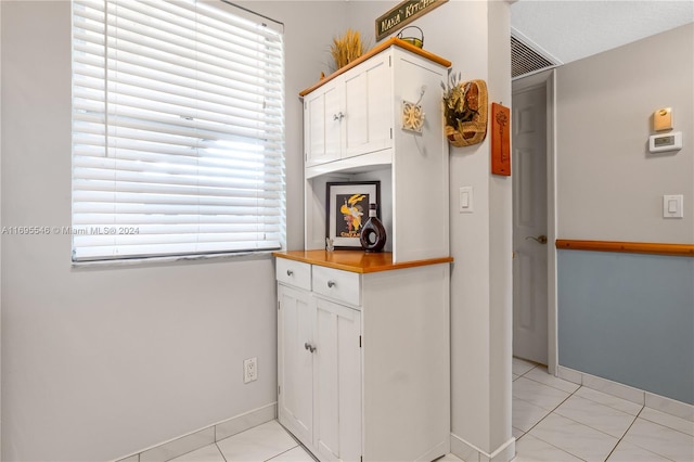 kitchen with light tile patterned flooring and white cabinetry