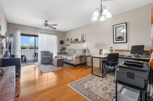 home office with hardwood / wood-style flooring and ceiling fan with notable chandelier