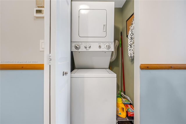 clothes washing area featuring stacked washing maching and dryer