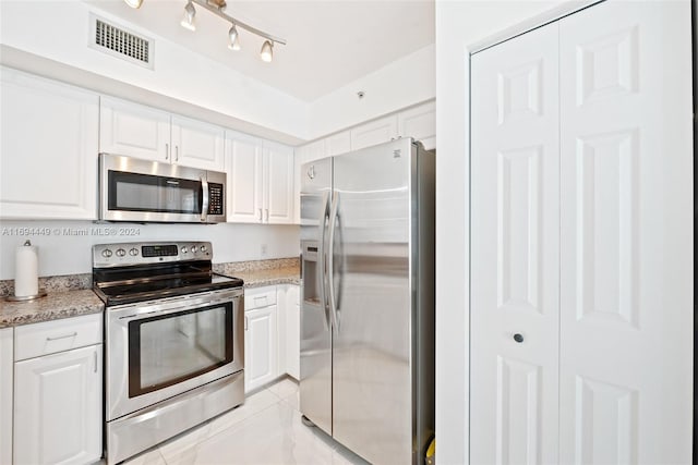 kitchen featuring light stone countertops, white cabinetry, and stainless steel appliances