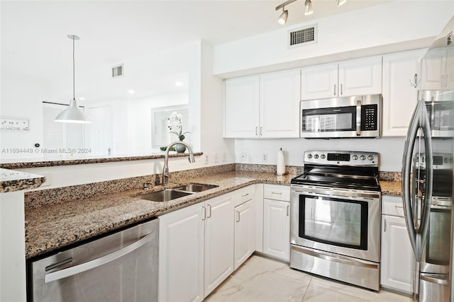 kitchen with dark stone countertops, white cabinetry, sink, and appliances with stainless steel finishes