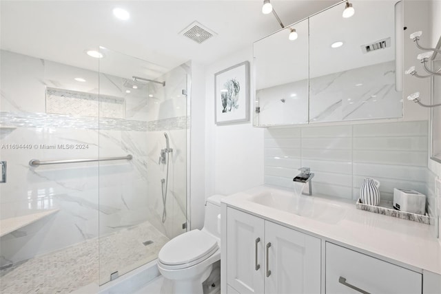 bathroom with tiled shower, vanity, and toilet