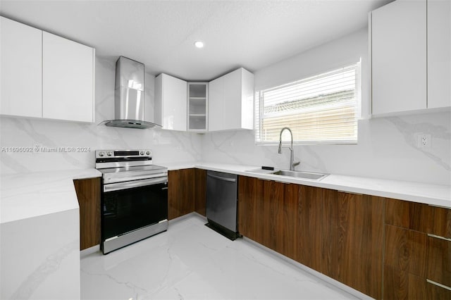 kitchen with white cabinets, wall chimney range hood, sink, and appliances with stainless steel finishes