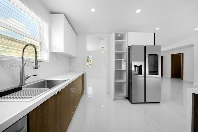 kitchen featuring stainless steel fridge with ice dispenser, dark brown cabinetry, white cabinetry, and sink