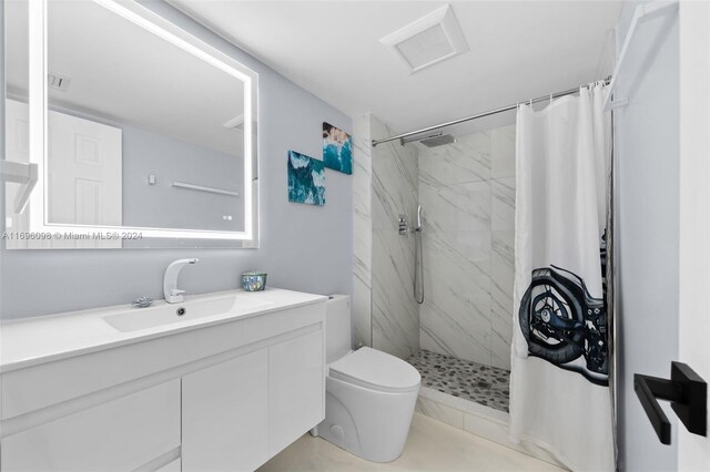 bathroom featuring curtained shower, vanity, and toilet