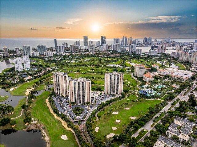 aerial view at dusk featuring a water view