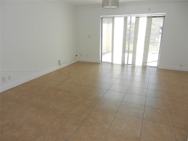 unfurnished room with light tile patterned floors and crown molding