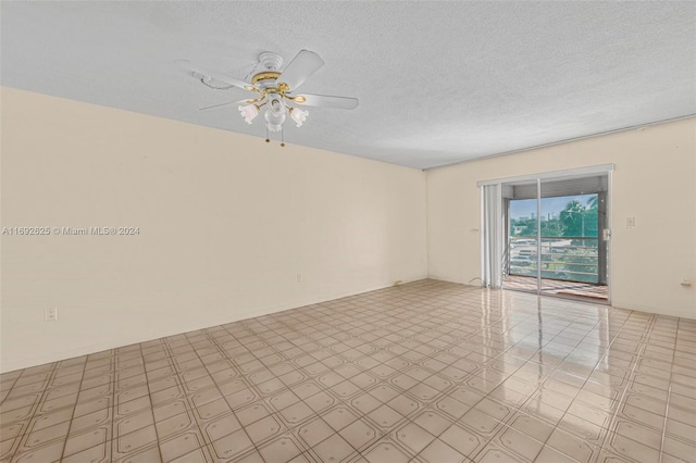 empty room with ceiling fan and a textured ceiling