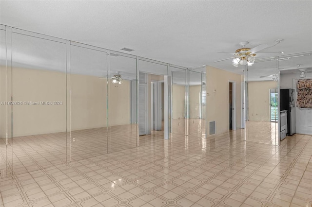 empty room featuring ceiling fan and a textured ceiling