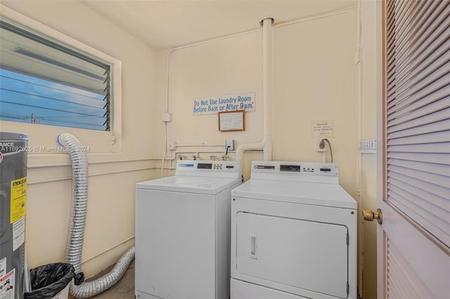 laundry room with separate washer and dryer and water heater