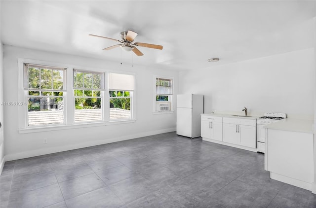 unfurnished living room with ceiling fan and sink