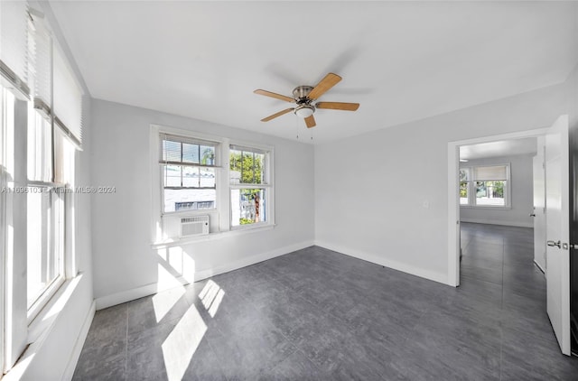 spare room featuring ceiling fan, cooling unit, and a healthy amount of sunlight