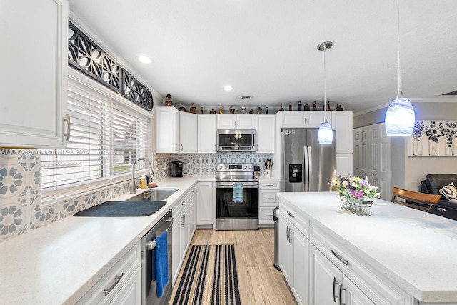 kitchen with white cabinetry, sink, light wood-type flooring, and appliances with stainless steel finishes