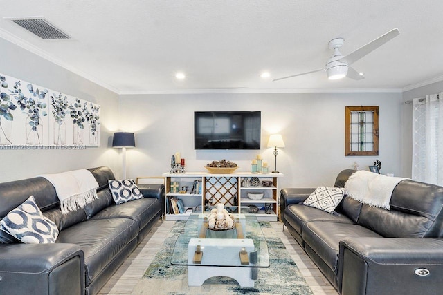 living room featuring light wood-type flooring, ceiling fan, and ornamental molding