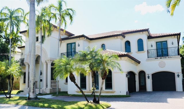 mediterranean / spanish house with a garage and a balcony