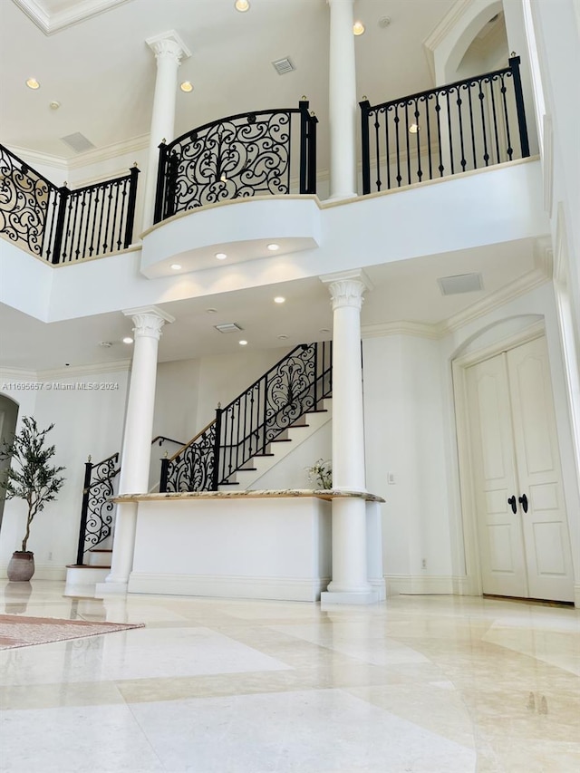 stairs featuring a towering ceiling and ornamental molding