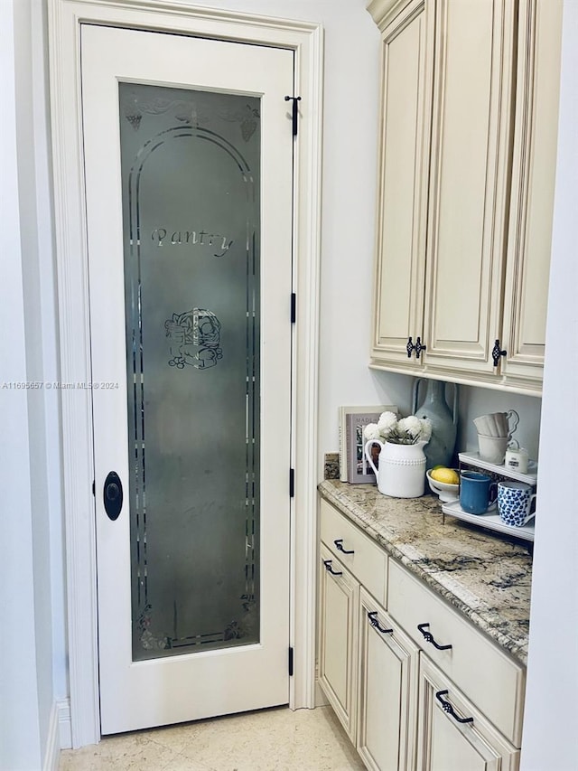 interior space featuring light stone countertops and cream cabinets