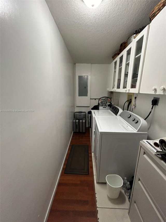 laundry room with cabinets, electric panel, dark hardwood / wood-style floors, independent washer and dryer, and a textured ceiling