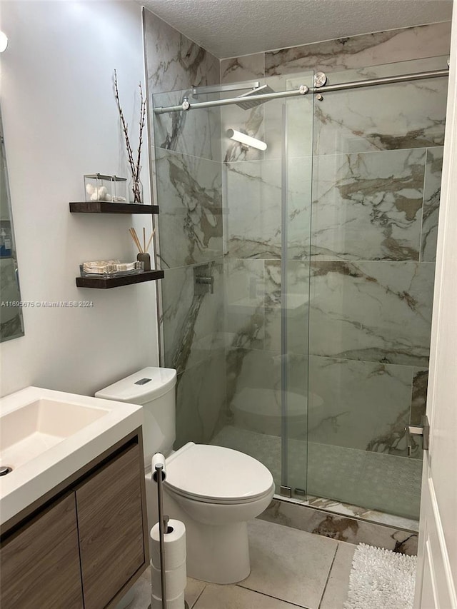 bathroom with tile patterned floors, an enclosed shower, a textured ceiling, vanity, and toilet