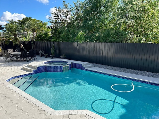 view of pool featuring an in ground hot tub and a patio