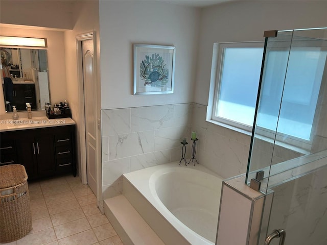 bathroom featuring tile patterned flooring, vanity, tile walls, and a bathing tub