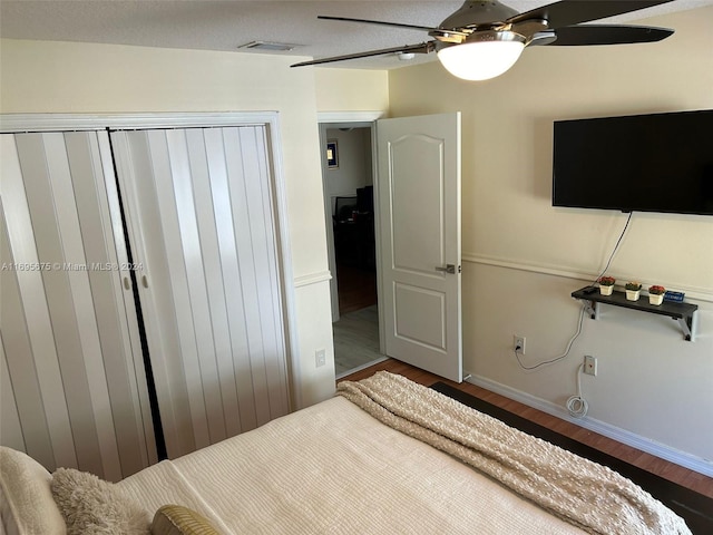 bedroom featuring wood-type flooring, a closet, and ceiling fan