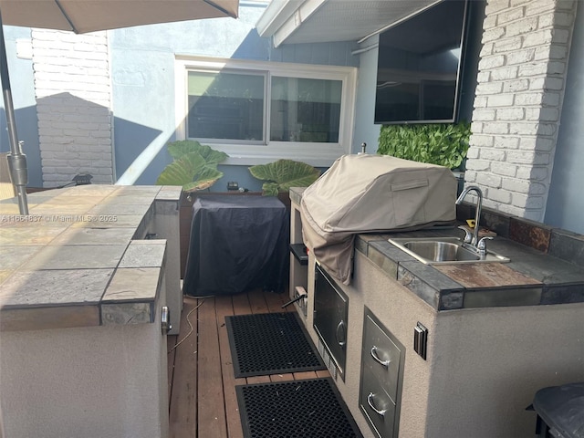 view of patio with area for grilling and a sink