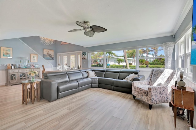 living area with light wood-style flooring, french doors, crown molding, and ceiling fan