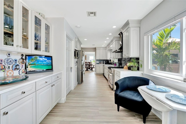 kitchen featuring tasteful backsplash, visible vents, light countertops, stainless steel appliances, and white cabinetry