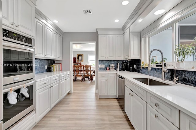 kitchen with visible vents, appliances with stainless steel finishes, decorative backsplash, and a sink