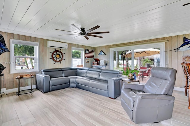 living area featuring wooden walls, a ceiling fan, light wood-style flooring, ornamental molding, and an AC wall unit