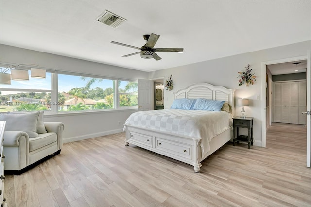 bedroom featuring visible vents, baseboards, light wood-style floors, and a ceiling fan