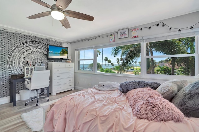 bedroom featuring baseboards, ceiling fan, and wood finished floors