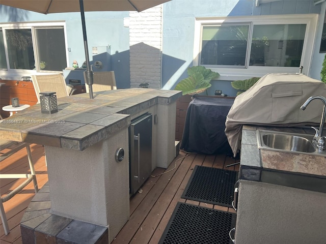 view of patio featuring a sink, exterior kitchen, outdoor wet bar, and a wooden deck