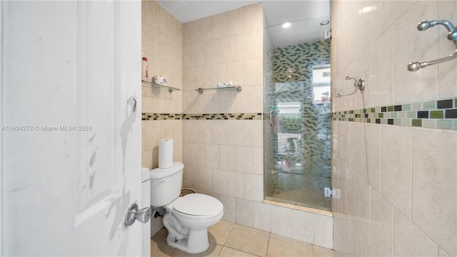 bathroom featuring tile patterned flooring, toilet, walk in shower, and tile walls