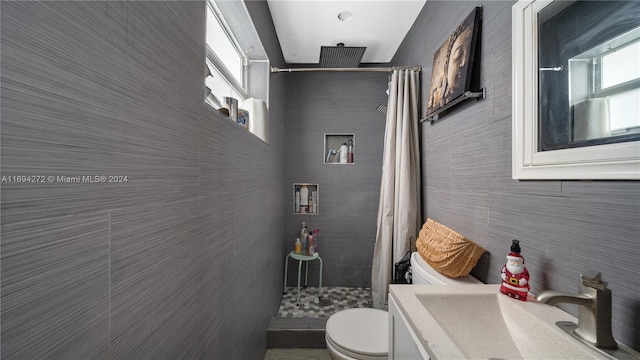 bathroom with curtained shower, vanity, a healthy amount of sunlight, and toilet