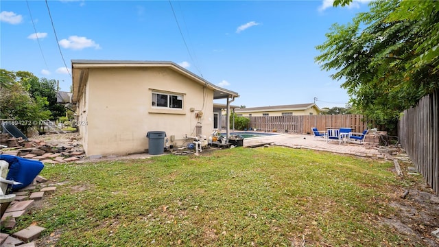 back of property with a lawn, a fenced in pool, and a patio