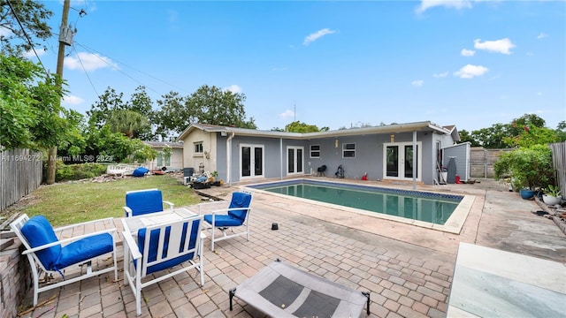 view of pool featuring a patio area, a yard, and french doors