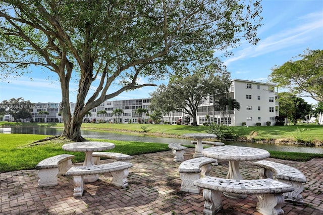 view of home's community featuring a yard, a water view, and a patio area