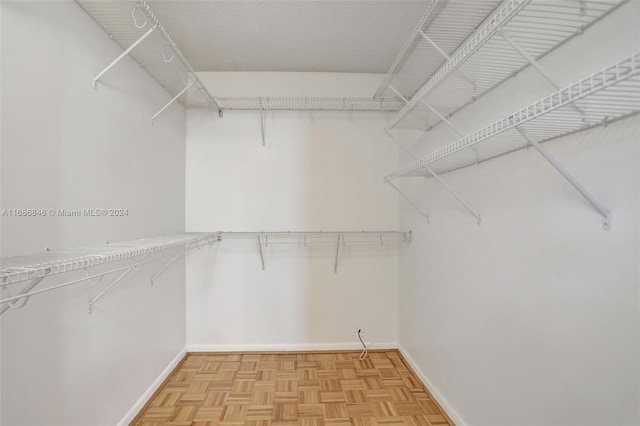 walk in closet featuring parquet flooring