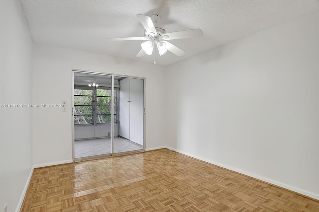 unfurnished room with ceiling fan, light parquet floors, and a textured ceiling