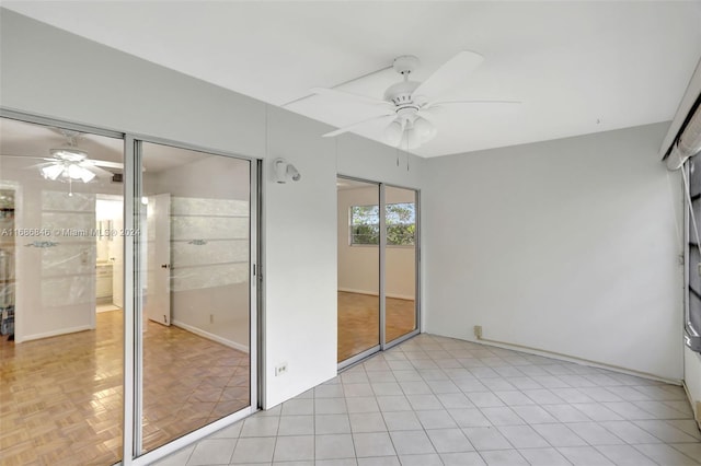 unfurnished bedroom with multiple closets, ceiling fan, and light parquet floors