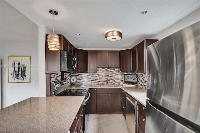 kitchen with pendant lighting, backsplash, sink, and stainless steel appliances