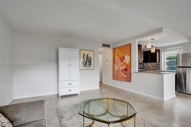 living room with light tile patterned floors and a textured ceiling