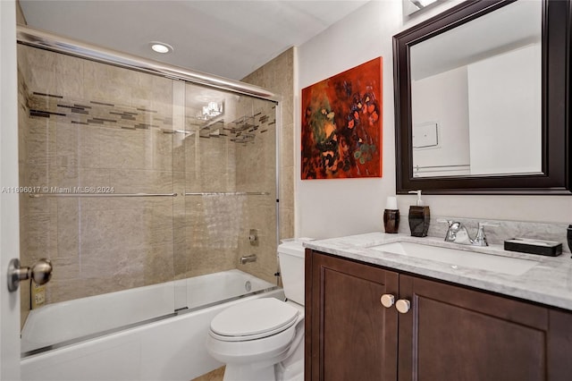 full bathroom featuring vanity, toilet, and bath / shower combo with glass door