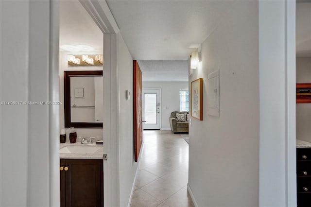 hallway featuring sink and light tile patterned floors