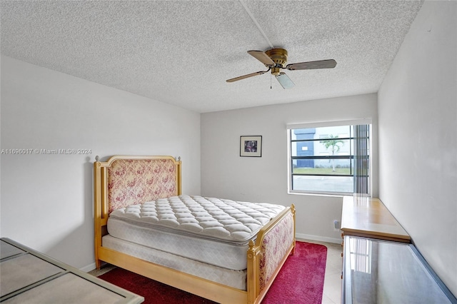 bedroom with ceiling fan and a textured ceiling