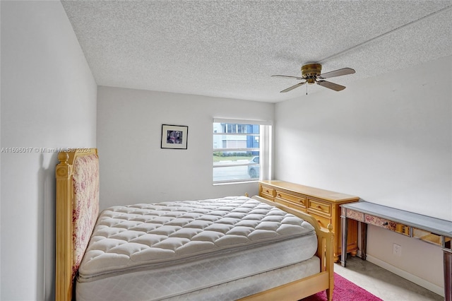 bedroom featuring ceiling fan, light carpet, and a textured ceiling